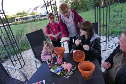 Menschen die zusammen einen Blumentopf anmalen
