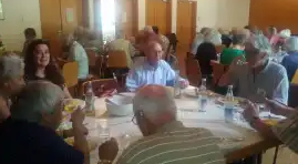 Viele Bürgerinnen und Bürger sitzen gemeinsam an Tischen und essen zu Mittag